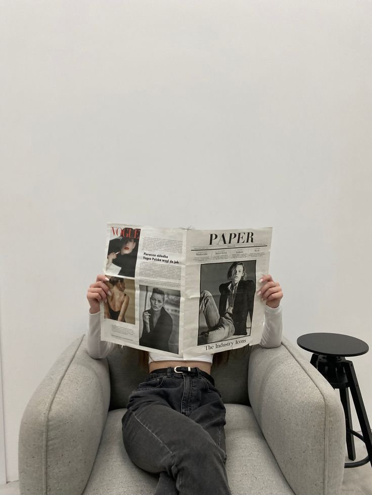 mujer leyendo periodico en un sillon